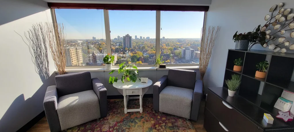 Private consultation room at Psyche PC in Denver with armchairs, city views, and natural light.