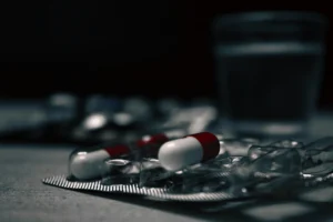 Shadowed image of medication with a glass of water